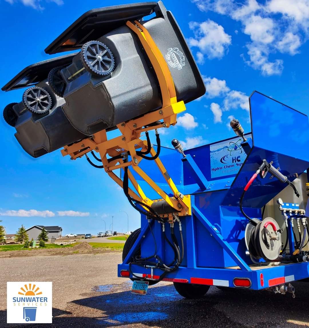 pressure washing services truck holding up two wheelie bins